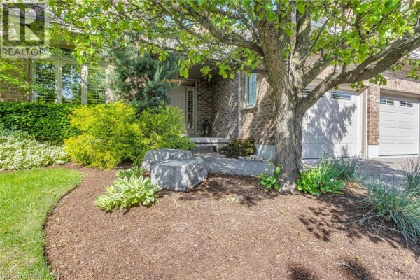 Brown hot tub on a stamped concrete patio next to a brick house during winter. - 211 Terrace Wood Crescent, Kitchener