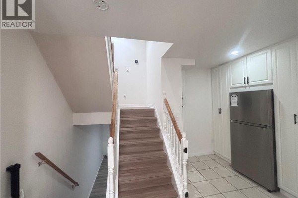 Interior view of a staircase with wood treads and white banisters, leading upstairs. White cabinetry is visible to the right. - 211 Veronica Drive Unit# B24, Kitchener