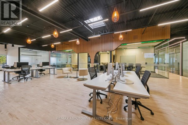 Spacious open office area with wooden accents, glass meeting rooms, and natural light - 211-c - 320 Matheson Boulevard W, Mississauga