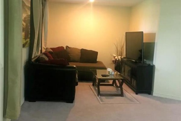 Living room featuring a large sectional sofa, coffee table, and television. - 2111 Countrystone Place Unit# Lower, Kitchener