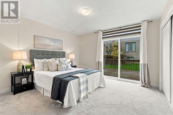 Primary bedroom with queen-size bed, nightstands, closet, and sliding glass doors to deck. - 2112 Meadowgate Boulevard, London South