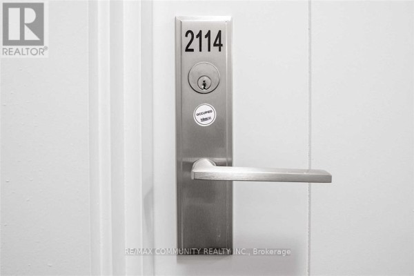 Close-up of apartment door number 2114 with a silver handle and lock. - 2114 - 2550 Simcoe Street N, Oshawa