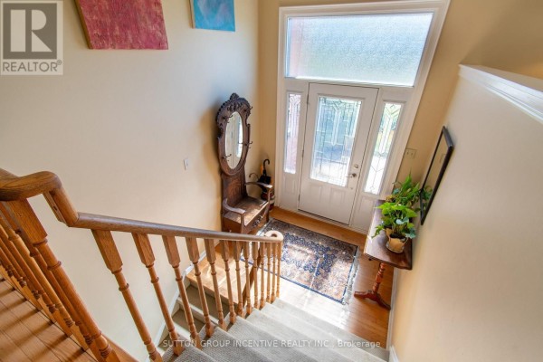 View of a staircase leading down to the front entrance with a glass door. - 2114 Chantler Street, Innisfil