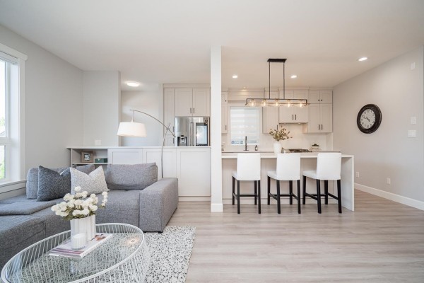 View of living room and kitchen with white island and bar stools. - 21149 79a Avenue, Langley