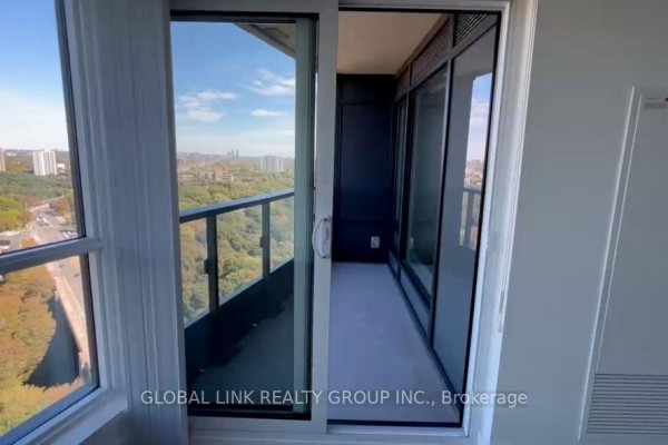 View of enclosed balcony with sliding glass door and window overlooking a city highway. - 2115 - 585 Bloor Street E, Toronto