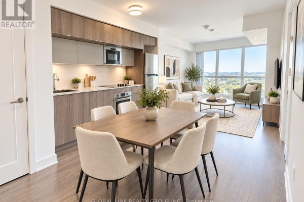 Open concept living and dining area with a modern kitchen, light wood floors, and city view. - 2115 - 585 Bloor Street E, Toronto
