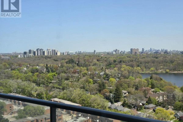 View of a treed neighborhood and a lake from a high-rise apartment balcony. - 2116 - 103 The Queensway Avenue, Toronto