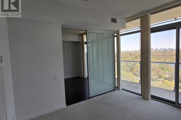 Interior of an apartment living room with carpet, large windows, and sliding door. - 2116 - 103 The Queensway Avenue, Toronto