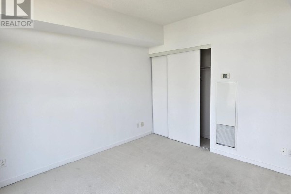 Interior of a bright bedroom with carpet and a large sliding closet door. - 2116 - 103 The Queensway Avenue, Toronto