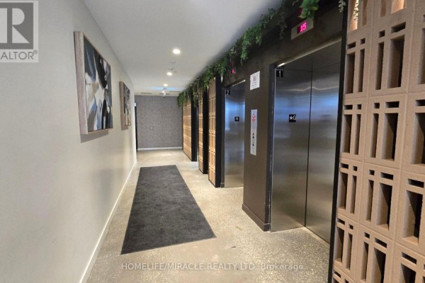A hallway in an apartment building with stainless steel elevator doors and modern art. - 2118 - 10 Abeja Street, Vaughan