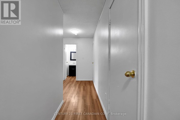 Kitchen with dark wood cabinets, granite countertops, and a dining area. - 212 - 1447 Huron Street, London East
