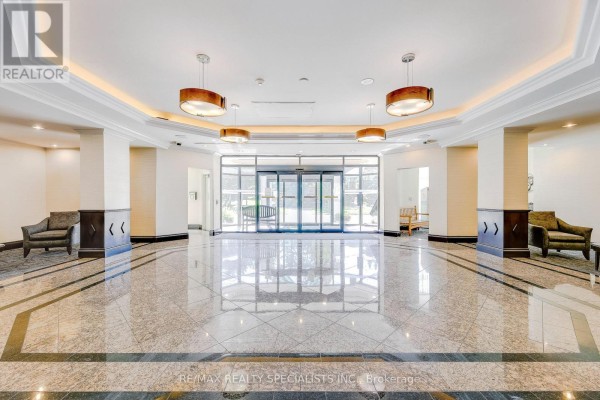 Spacious building lobby with polished marble floors, glass automatic doors, and seating areas. - 212 - 2155 Burnhamthorpe Road W, Mississauga