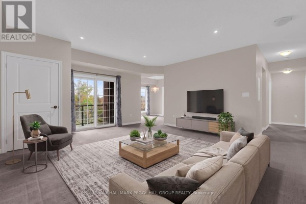 Living room with a beige sectional sofa, glass coffee table, and large sliding glass door. - 212 - 5 Greenwich Street, Barrie