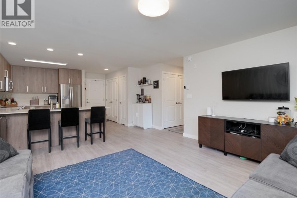 Open concept living area showing a kitchen with island, dining area, and living room. - 212 110 Presley Pl, View Royal