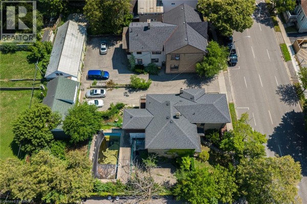 Aerial view of two houses, one with an overgrown pool area and parking. - 212-218 Dalhousie Street, Brantford