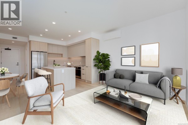 Empty living room with view of the kitchen and light wood flooring. - 212 3564 A Ryder Hesjedal Way, Colwood