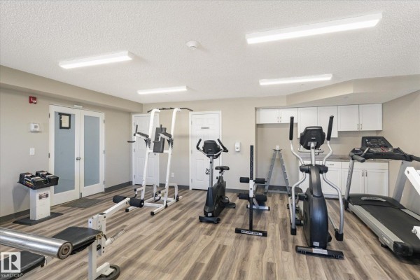 Apartment building gym with treadmills, stationary bikes, rowing machine, and weight equipment. - #212 6925 199 St Nw, Edmonton