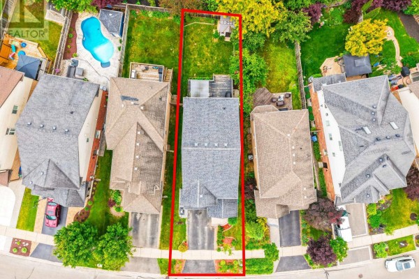 Aerial view of the property highlighting the house, driveway, backyard, and neighboring houses. - 212 Goodwin Drive, Guelph
