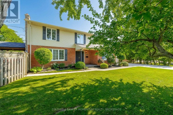 Side view of a brick and siding house with large trees and green lawn. - 212 Livingston Avenue, Grimsby