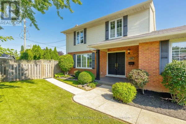 Entrance of a two-story house with red brick lower level and white siding. - 212 Livingston Avenue, Grimsby