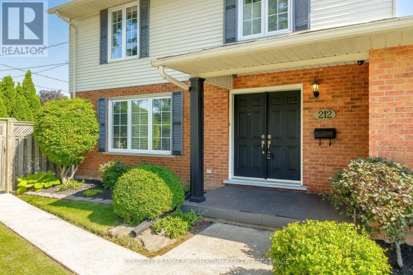 Close-up of the front entrance of a house with double black doors and brick facade. - 212 Livingston Avenue, Grimsby