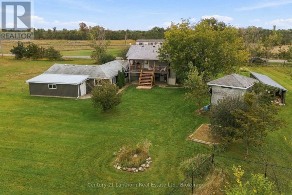 Aerial view of a property with a main house, garage, and outbuildings surrounded by a large green lawn. - 212 Old Milford Road, Prince Edward County