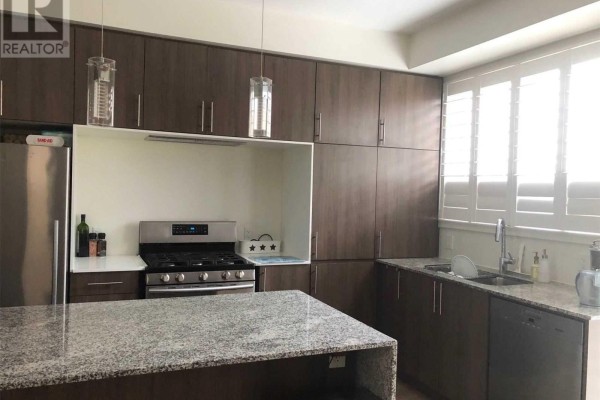 Kitchen with granite island, stainless steel stove, sink, dishwasher, and dark wood cabinetry with white plantation shutters. - 212 Squire Crescent, Oakville
