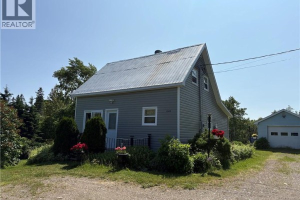 Grey house with a metal roof and green siding. Front entrance with two windows. Sunny day. - 2123 Sainte-louise, Sainte Louise