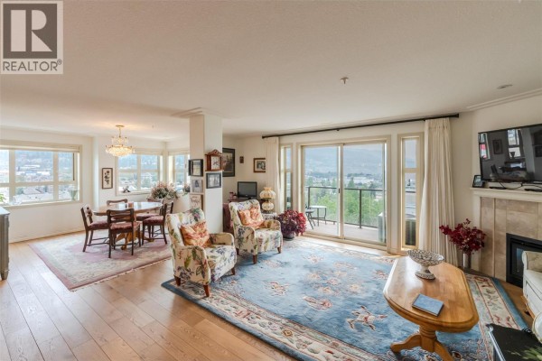 Living room with dining area, chairs, fireplace, and balcony access. - 2125 Atkinson Street Unit# 901, Penticton