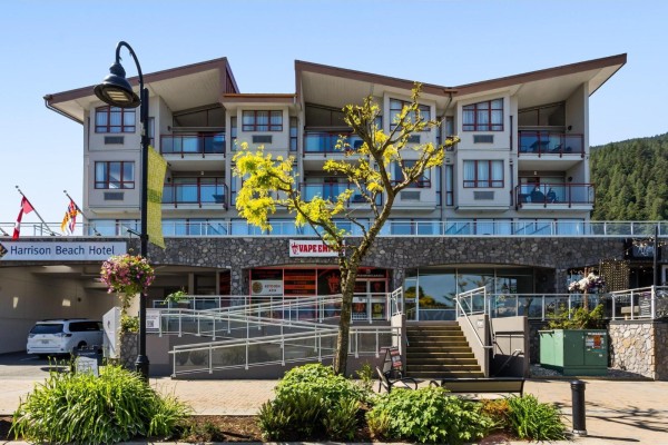 Exterior view of the Harrison Beach Hotel with stone and wood facade. - 212c 160 Esplanade Avenue, Harrison Hot Springs, Harrison Hot Springs