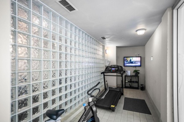 Fitness room with treadmills, stationary bike, and glass block wall. - 212c 160 Esplanade Avenue, Harrison Hot Springs, Harrison Hot Springs