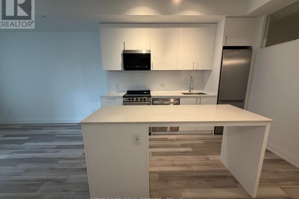 Modern kitchen with white cabinets, stainless steel appliances, and a white island with quartz countertop. - 213 - 3250 Carding Mill Trail, Oakville