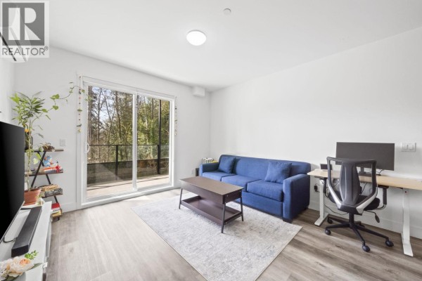 Kitchen with stainless steel refrigerator, white cabinets, quartz countertops, and pendant lighting. - 213 12320 222 Street, Maple Ridge
