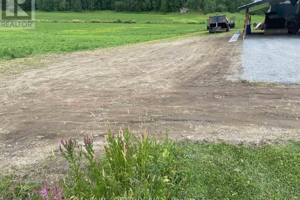 Wide view of the property showing the storage building and surrounding grassy landscape. - 2130 Du Golf Road, Clarence Rockland