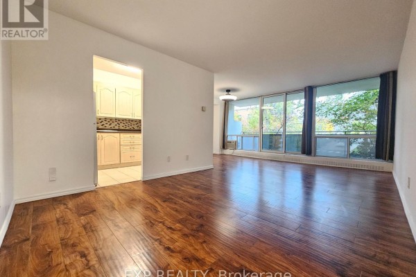 Apartment building lobby with tiled floors, wood-paneled walls, brick accent wall, and bench seating. - 214 - 10 Sunrise Avenue, Toronto