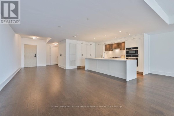 Spacious open concept living area with dining space and a modern kitchen. - 214 - 155 Merchants' Wharf, Toronto