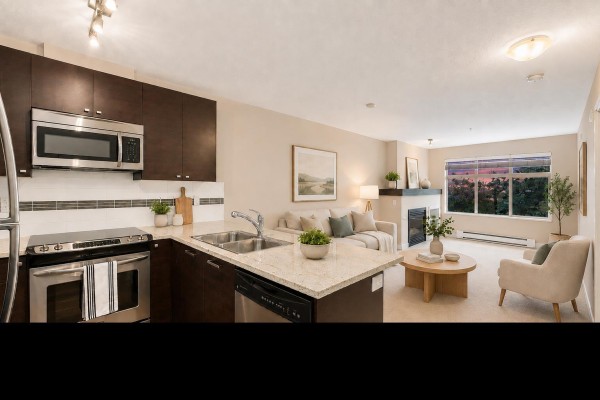 Modern kitchen with dark cabinetry, stainless steel appliances, and open layout to living area. - 214 6500 194 Street, Surrey