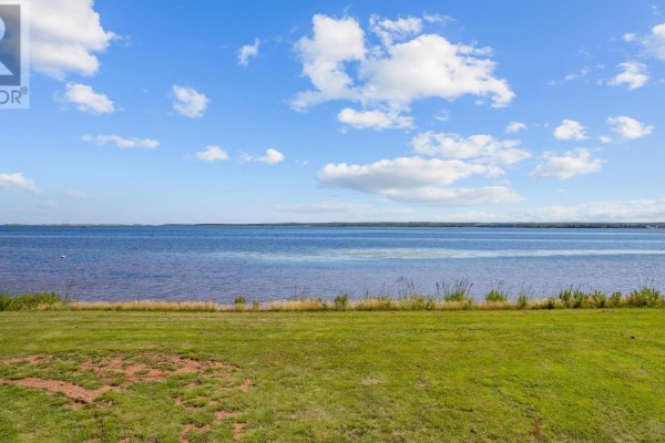 View of a calm body of water with scattered houses and green landscape along the shore. - 214 Hebrides Lane, New London, Stanley Bridge