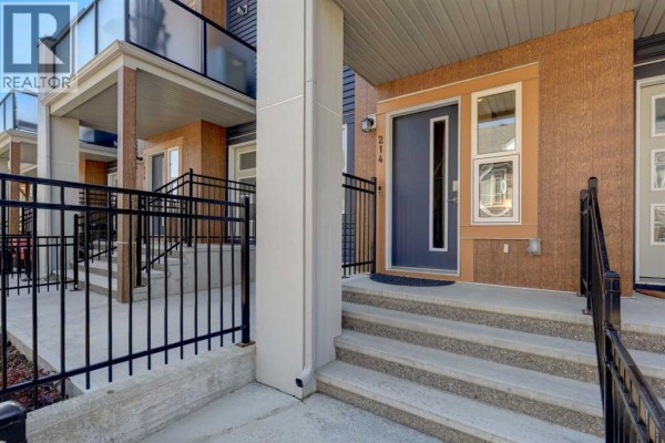Entranceway inside a townhouse with a white door, windows, and a decorative clock. - 214 Livingston Common Ne, Calgary