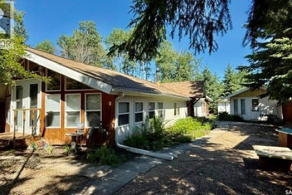 Open-concept living and dining area with wood-paneled walls, vaulted ceiling, and large windows. - 214 Richard Drive, Barrier Lake