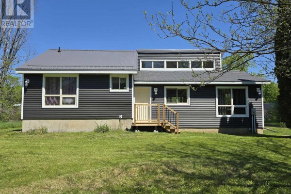 Side view of the house with snow, grass, and trees in the background - 2147 Marlbank Road, Tweed)