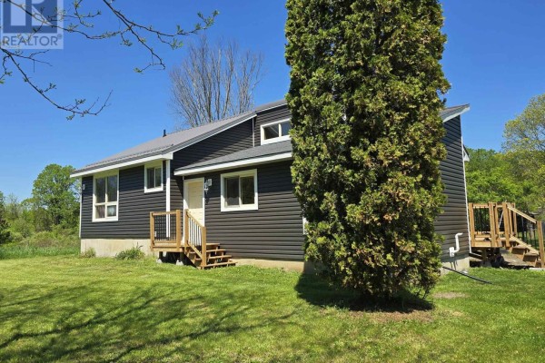 House exterior showing snow-covered ground and surrounding trees - 2147 Marlbank Road, Tweed)