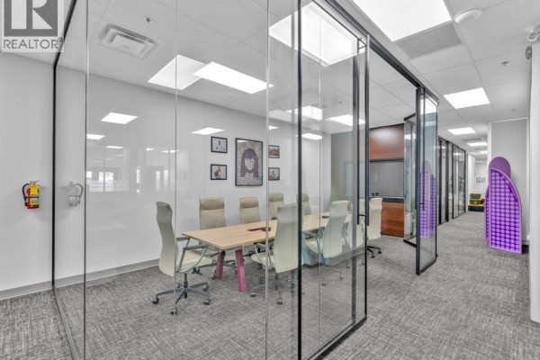 Interior view of a modern office space with glass-walled conference rooms and carpeted floors. - 215 Eugenie Street West Unit# 101, Windsor