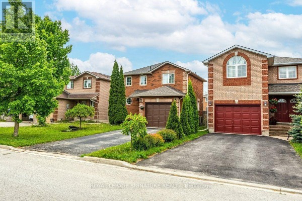 Street view of a residential block featuring brick houses with garages and driveways. - 215 Turnbridge Road, Barrie