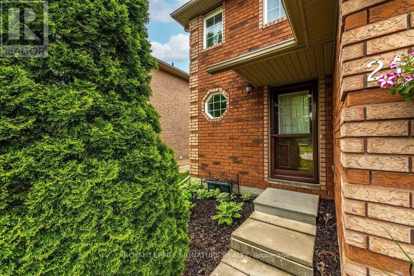 Close-up of the front entrance of a brick house with a covered walkway and a round window. - 215 Turnbridge Road, Barrie