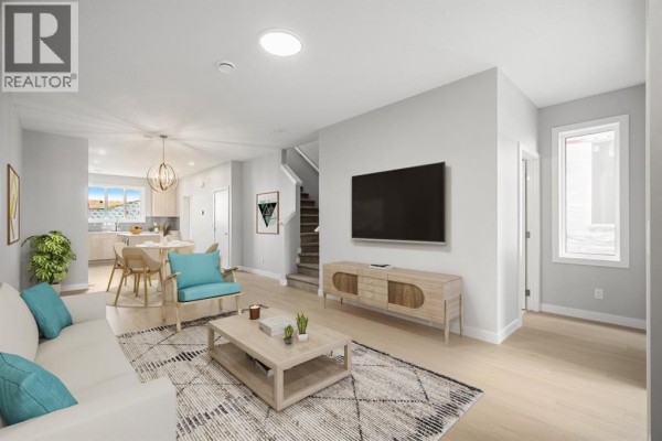 Open concept living and dining area with light wood floors, modern furniture, and a distant kitchen view. - 21527 Sheriff King Street Sw, Calgary