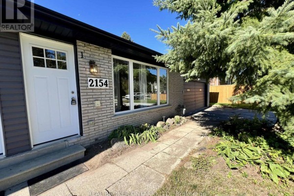 Front entrance of the house with a white door, stone facade, and address number 2154. - 2154 Adullam Avenue, Innisfil