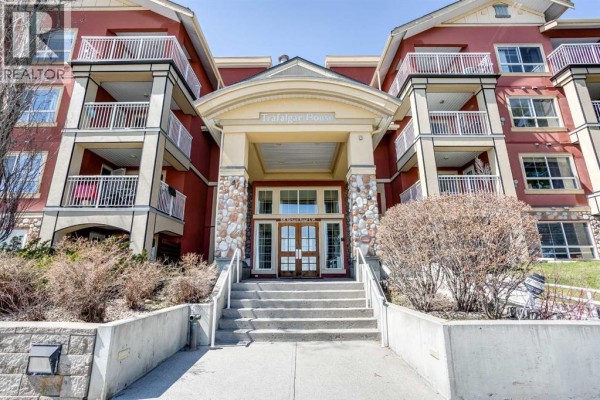 Close-up of the main entrance to the Trafalgar House apartment building with stone accents. - 216, 5115 Richard Road Sw, Calgary
