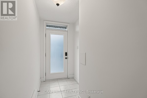 Interior view of entryway with white walls, tiled floor, and frosted glass door. - 216 - 581 Takamose Private, Ottawa