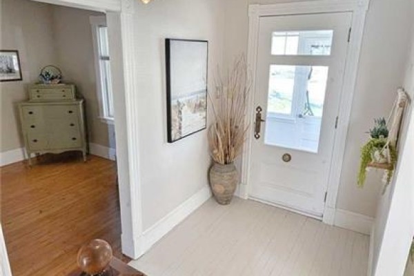 Interior entryway with white double doors, a dresser, and wooden floors. - 216 Boul. Saint-pierre O, Caraquet